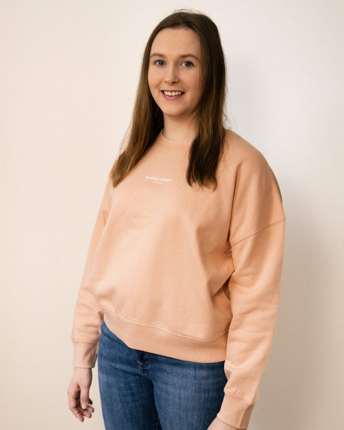 Braunhaarige Frau mit cropped Pullover Farbe peach